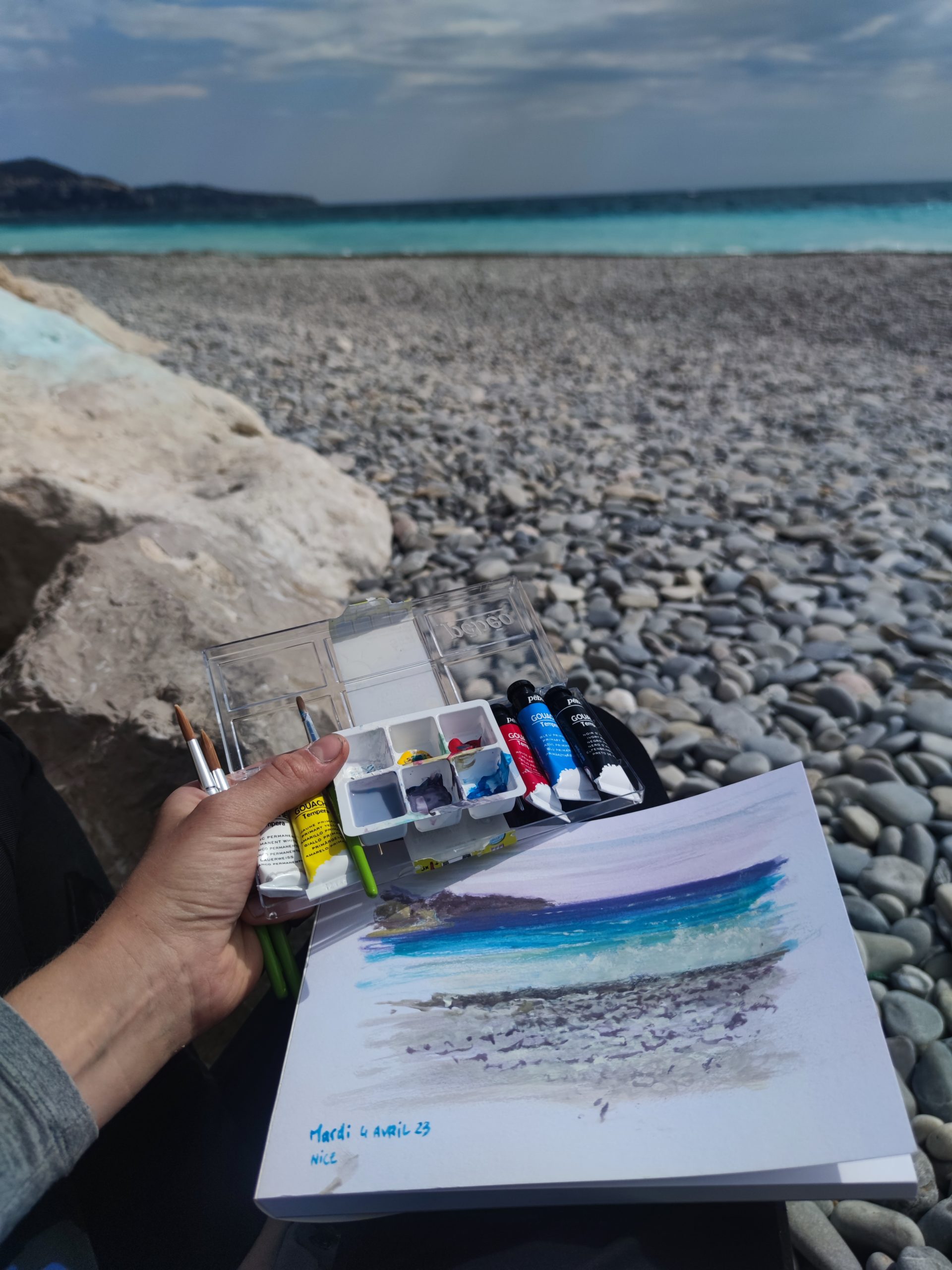 Moment de peinture sur le vif sur la plage de Nice devant la mer méditéranée